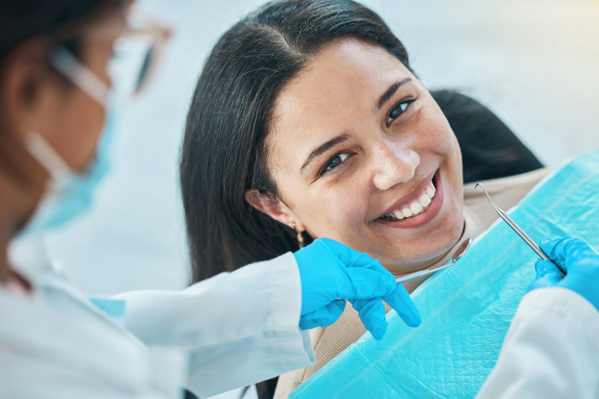 Woman, face and teeth whitening, dentist and dental with health, smile in portrait during procedure